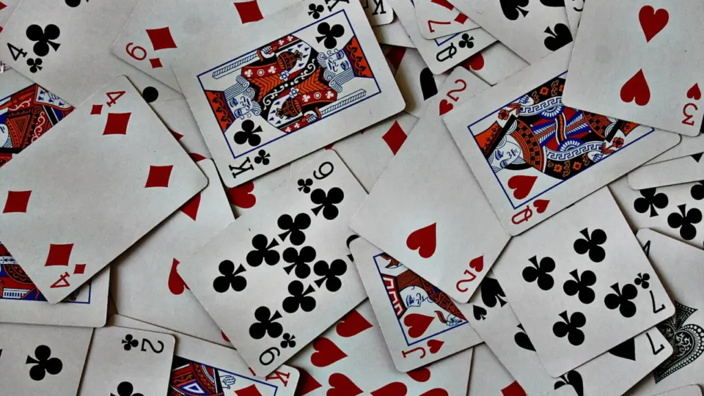 Daugybė skirtingų lošimo kortų išdėliotų ant stalo parodos pristatymui.