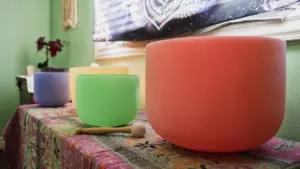 Spalvoti krištoliniai dubenys meditacijai padėti ant stalo Marijampolės kultūros renginio kontekste.