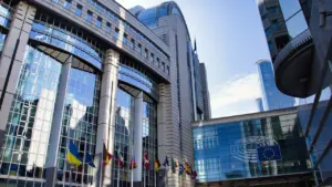 Moderni Europos Parlamento pastato išorė su vėliavomis ir dangumi Briuselyje, Belgijoje